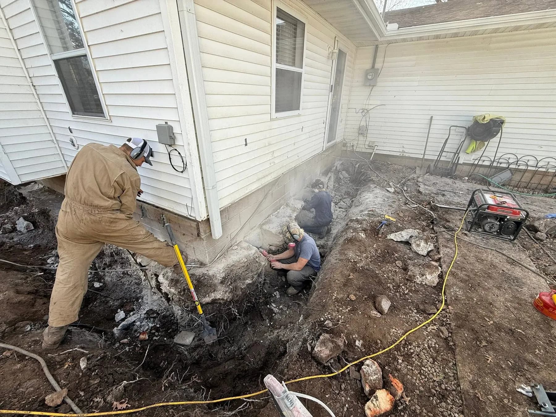 Crew excavating along a foundation