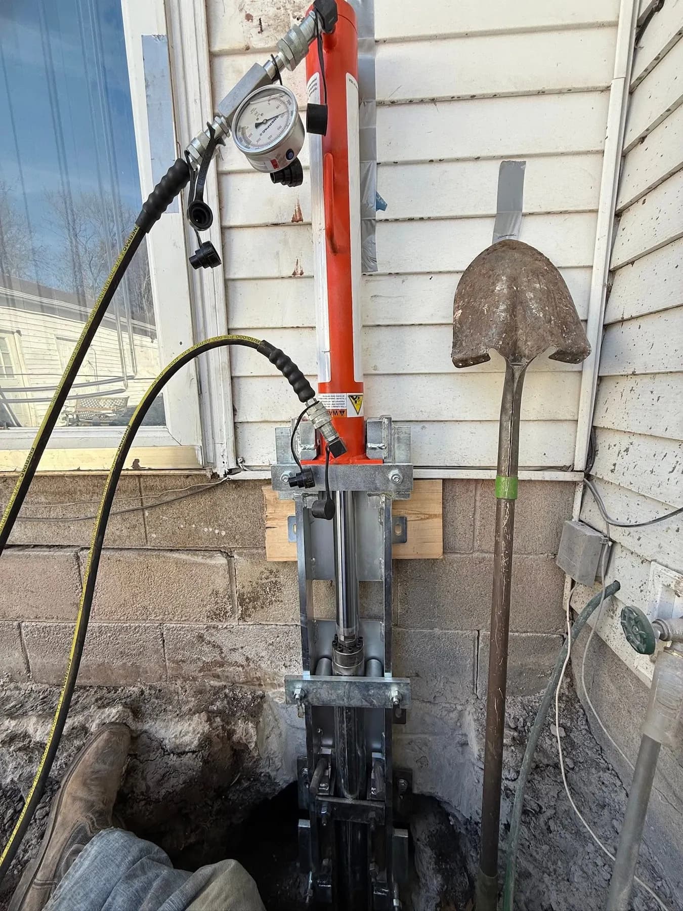 Pier drive system mounted on a foundation wall