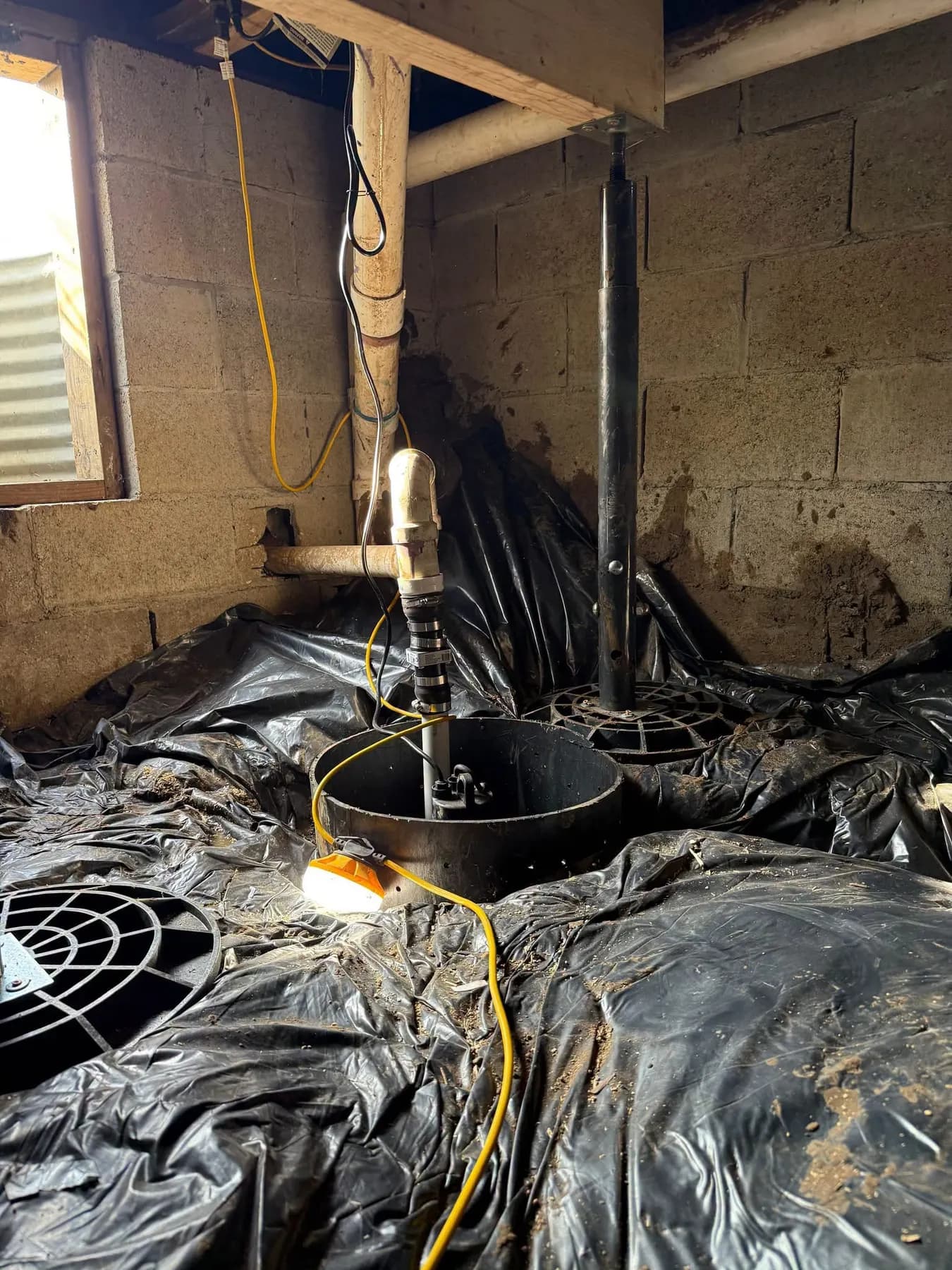Sump pump basin being installed during a basement waterproofing project